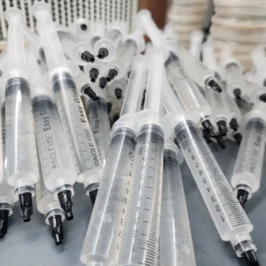 50 spore syringes laid out on a table in a pile