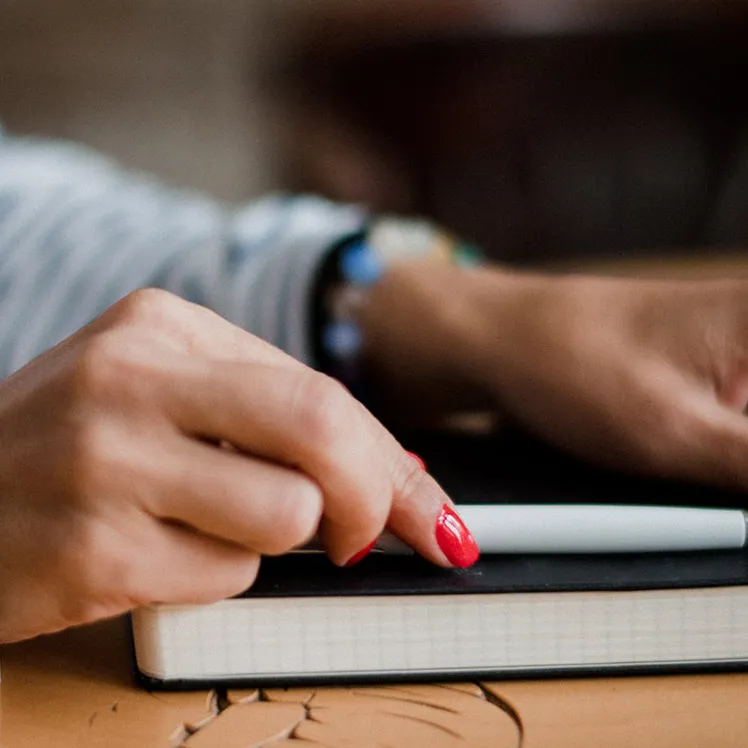 Blog page image of a person with a notebook and pencil.