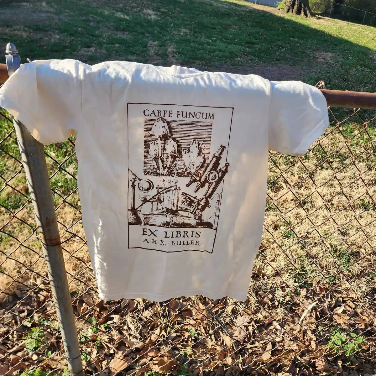 Front view of a cream-colored Carpe Fungum tee featuring a brown vintage mushroom illustration by A.H.R. Buller.