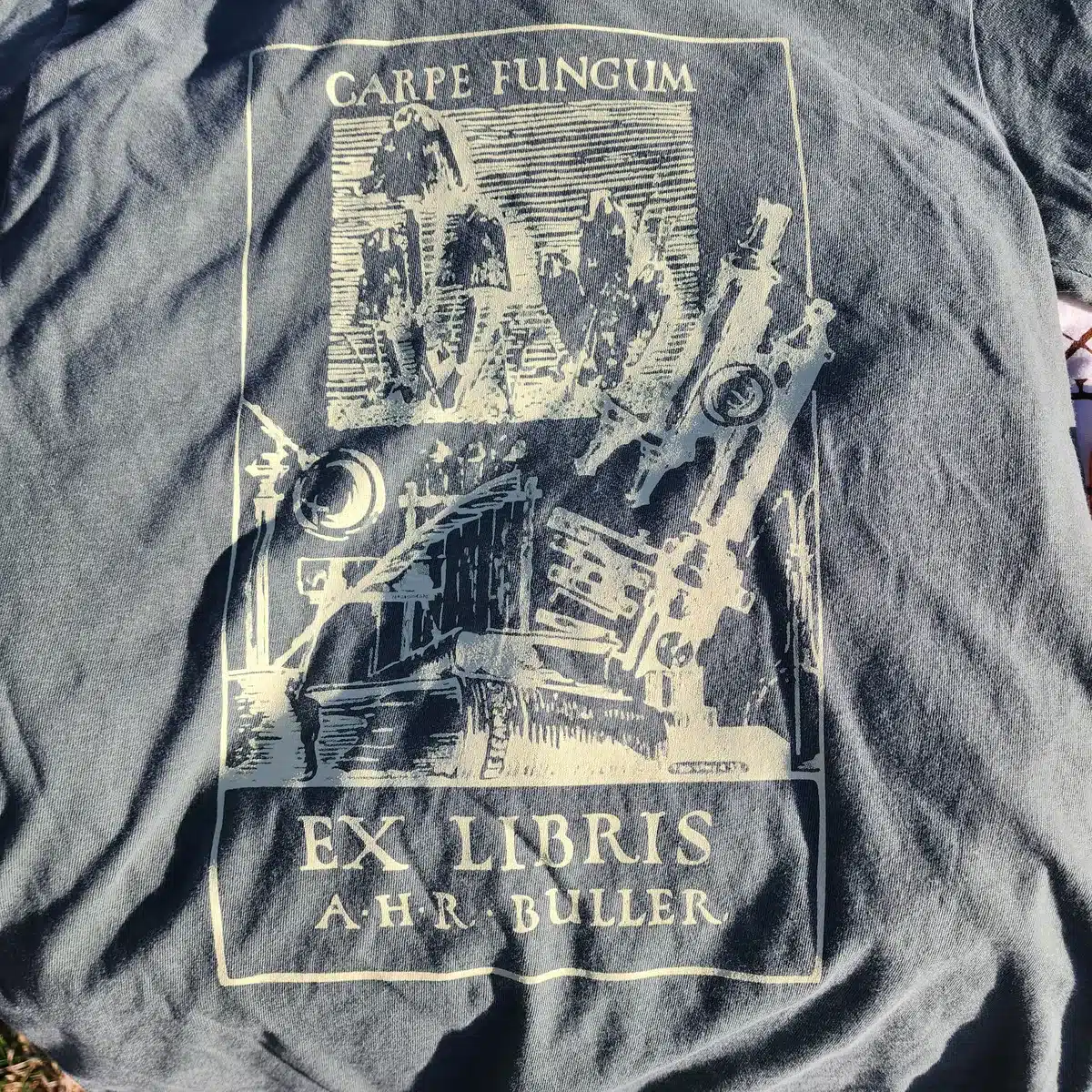 Front view of a green Carpe Fungum tee with bright yellow vintage mushroom illustration by A.H.R. Buller on the chest.