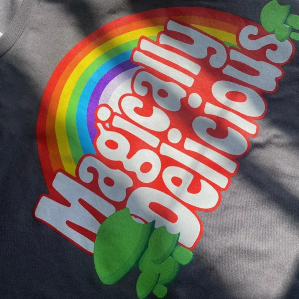 Grey short with a mock logo of a popular cereal brand. Says magically delicious with little green shamrock basidium Logos