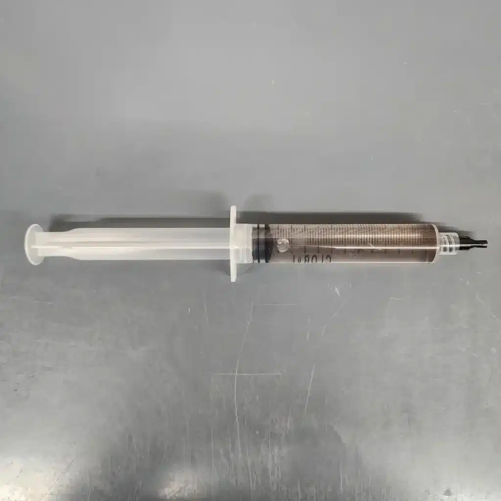 Staff Pick Syringe with a random spore syringe sitting on a table